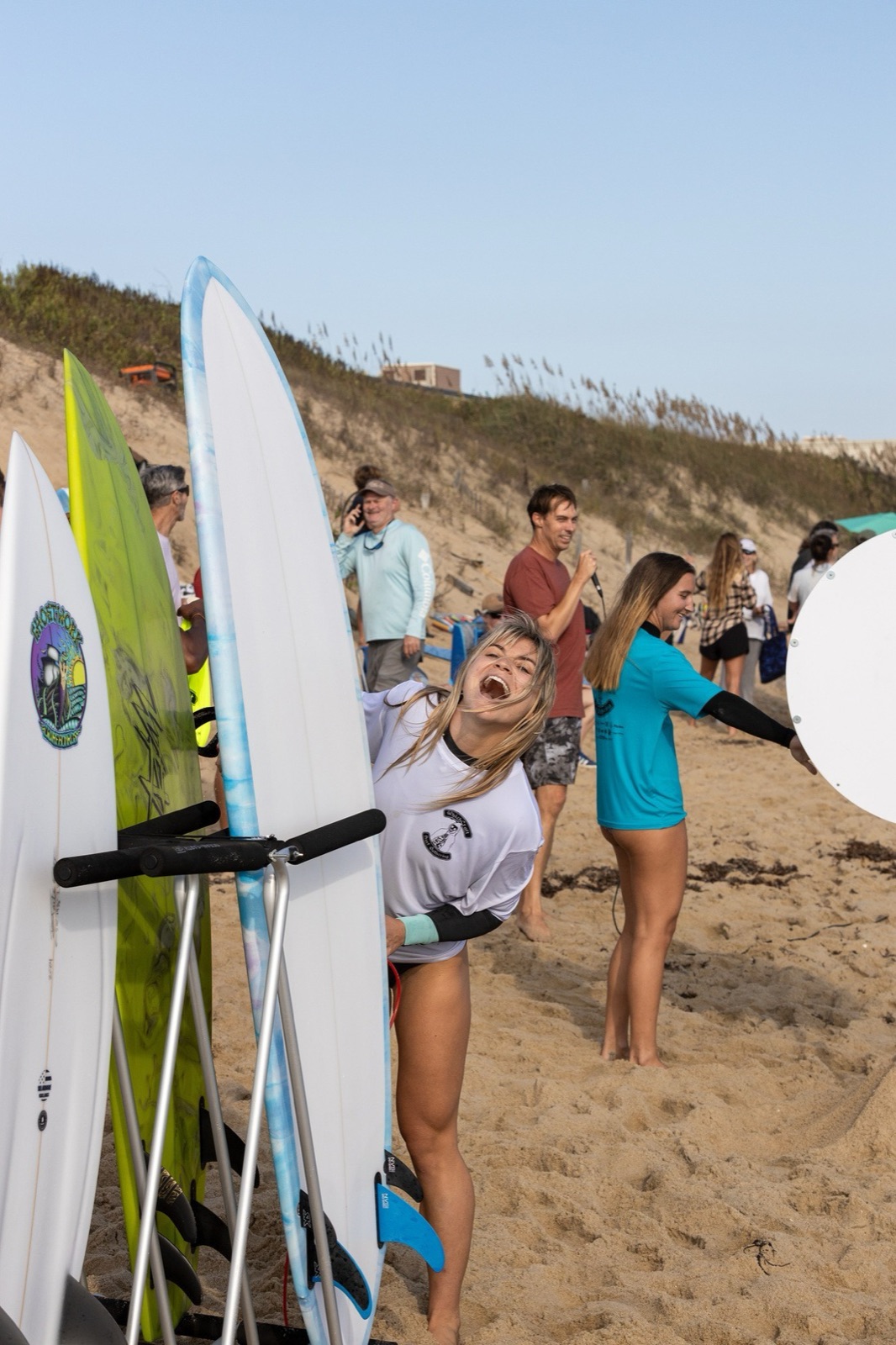 A laughing surfer pulls a board from the rack at the Which Craft Surf Gathering
