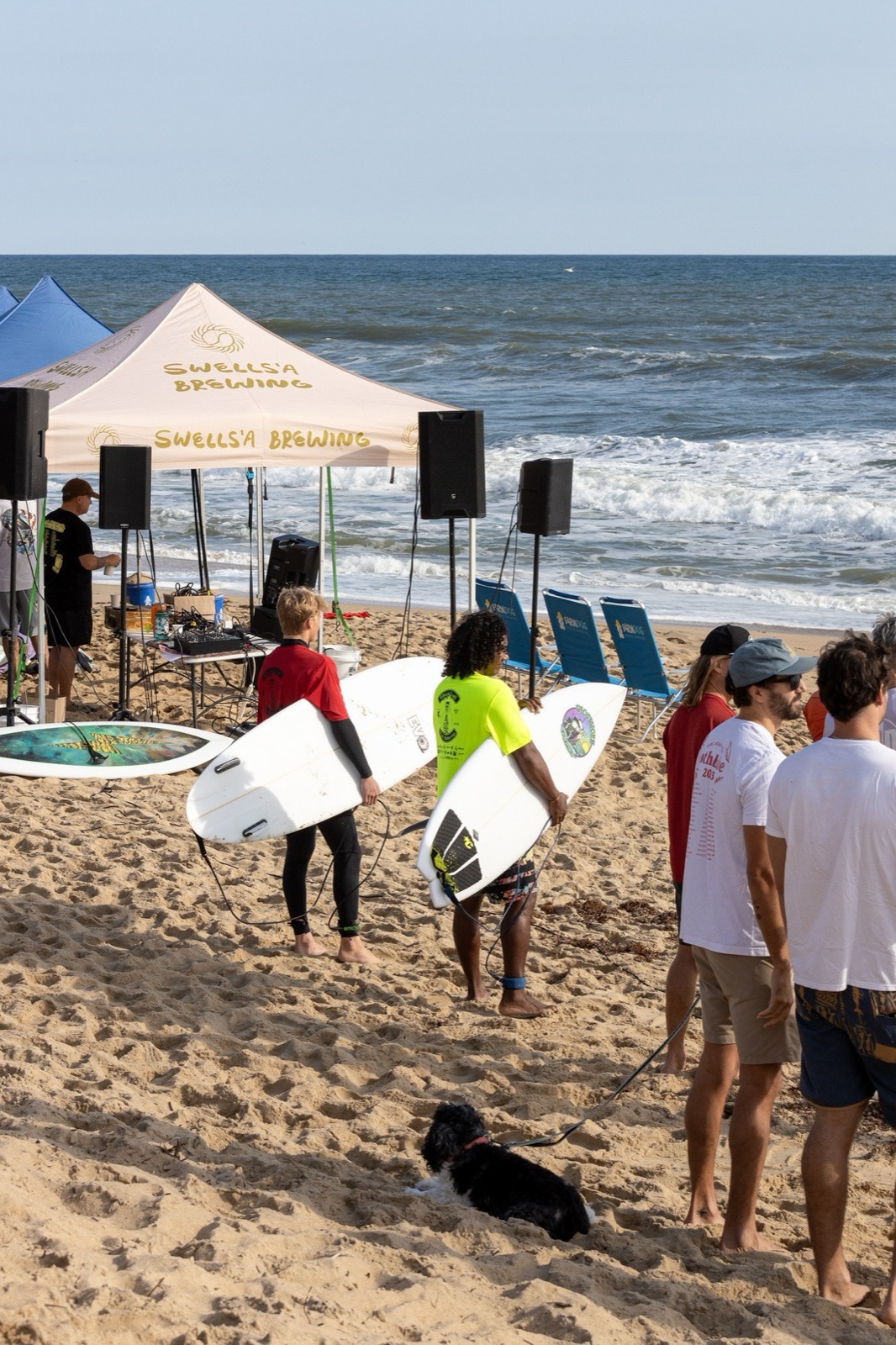 Competitors carry boards past the Swells'a Brewing tent